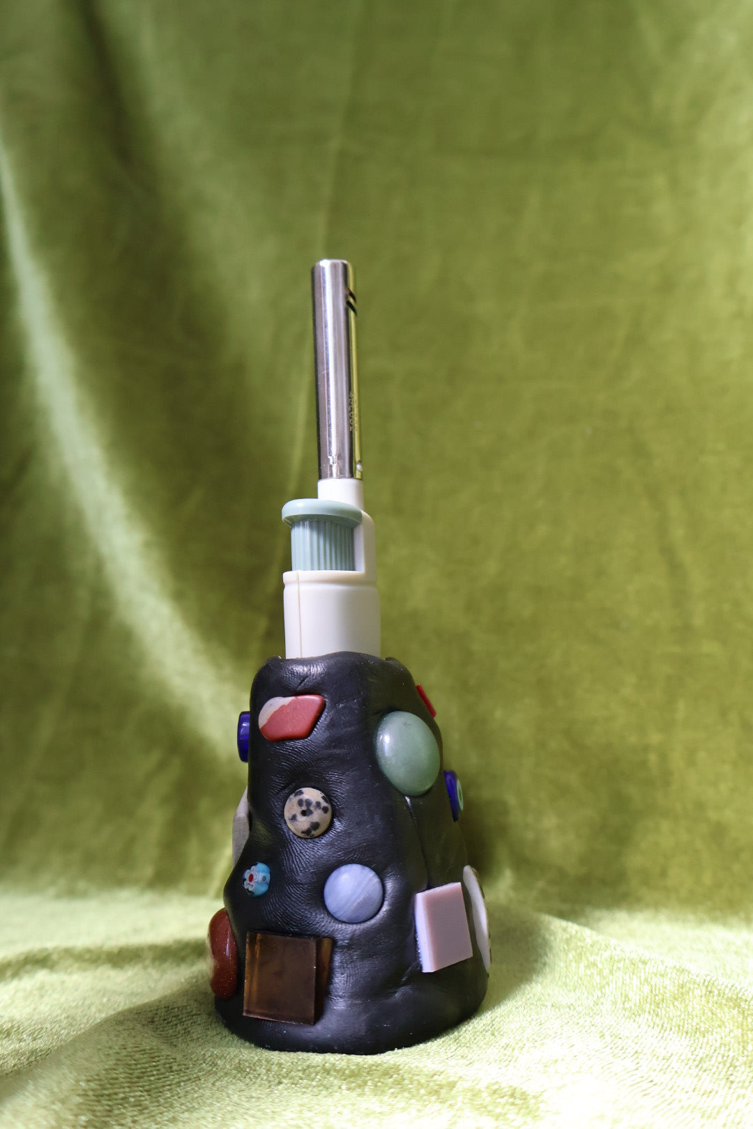 moss gem mosaic lighter holder on green velvet; lighter not included